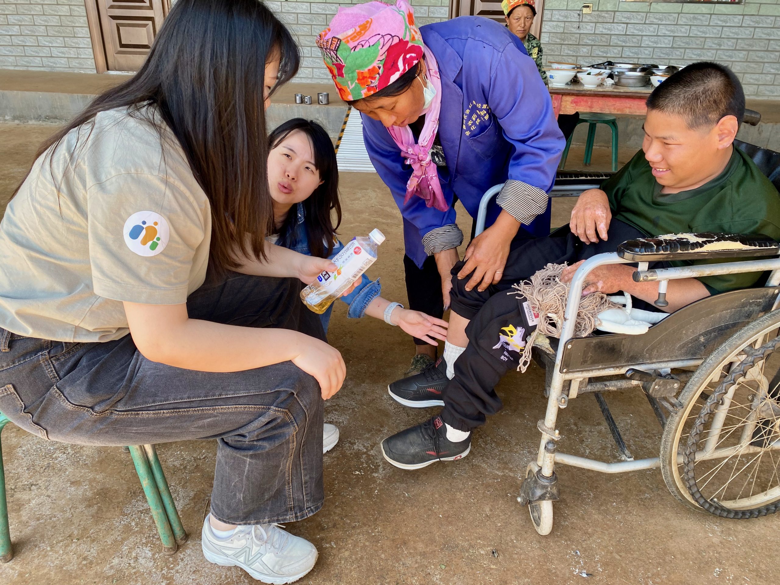 Boy in wheelchair in China and his family receiving support from therapist